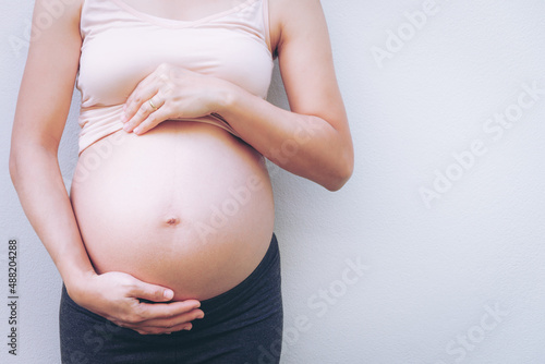 Close up of pregnant woman touching her belly.  © Ayla