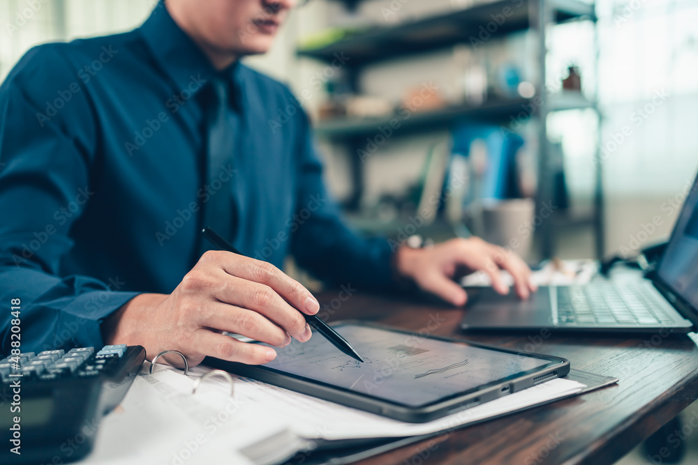 Business hand hold stylus pen touch screen digital tablet with business diagram on the table workspace. Business hand hold stylus pen touch screen digital tablet with business diagram on the table workspace.
