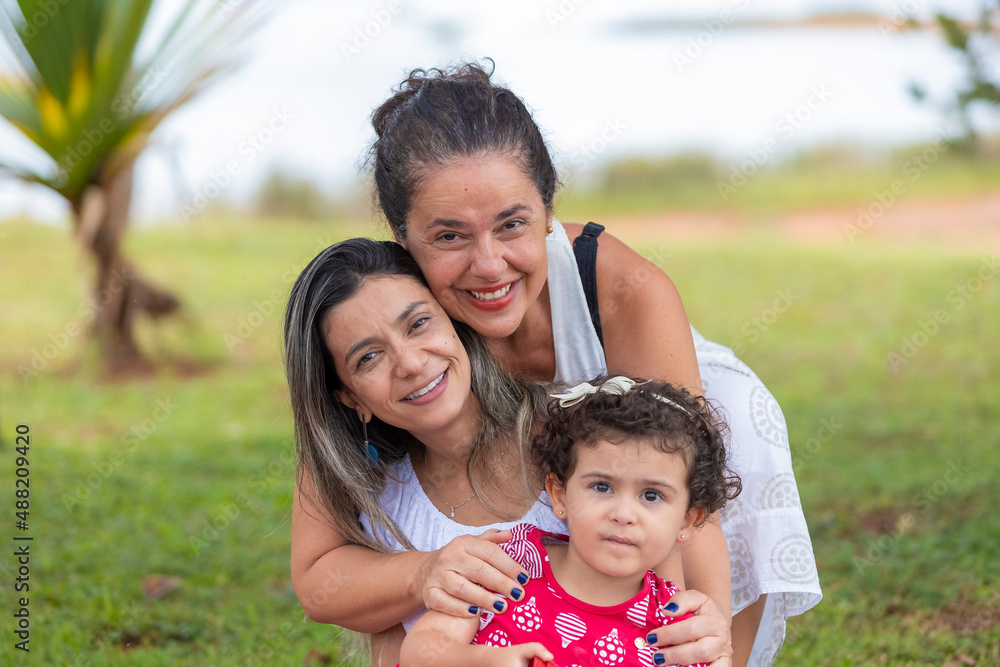 family of gay women with their daughter making a face, blurred background family of gay women with their daughter making a face, blurred background
