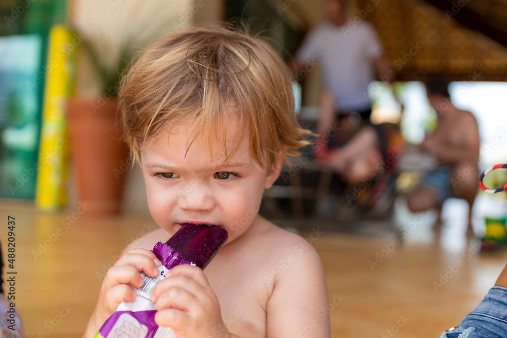 baby sucking grape popsicle, narrow focus baby sucking grape popsicle, narrow focus