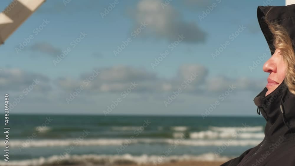 Young woman closed her eyes against the backdrop of bright spring sky with clouds, sunbathing basking in the sun. Hair fluttering in the wind, close-up. outdoor recreation, privacy Young woman closed her eyes against the backdrop of bright spring sky with clouds, sunbathing basking in the sun. Hair fluttering in the wind, close-up. outdoor recreation, privacy