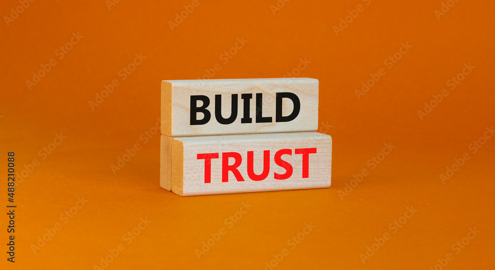 Build trust symbol. Concept words Build trust on wooden blocks on a beautiful orange table orange background. Business and build trust concept, copy space. Build trust symbol. Concept words Build trust on wooden blocks on a beautiful orange table orange background. Business and build trust concept, copy space.