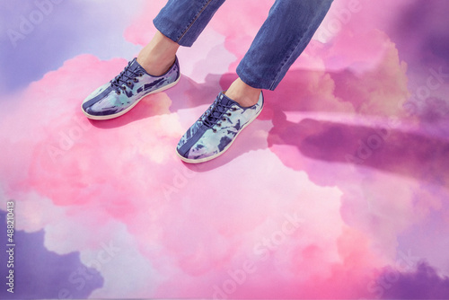 Man legs in jeans and stylish sneakers isolated on pink cloud sky background, space for text