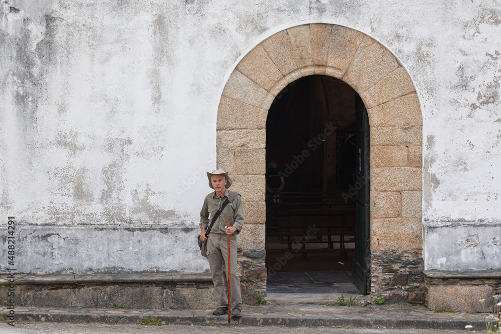 Pilgrim with hat, bag and cane in Church on the Camino de Santiago. Way of St James