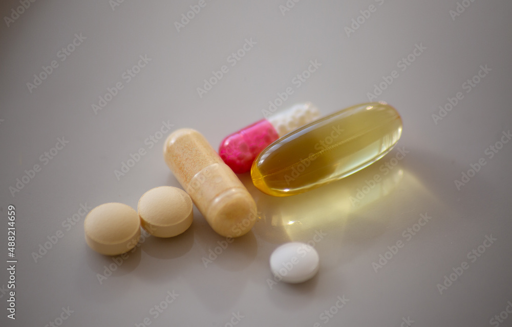 different pills and capsules on white surface different pills and capsules on white surface