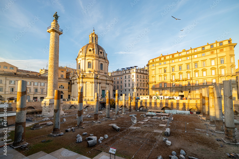 Obraz premium Ruins of Roman forum with Trajan column and church of the Most Holy Name of Mary. Rome cityscape on sunset. Concept of historical landmarks and travel Italy