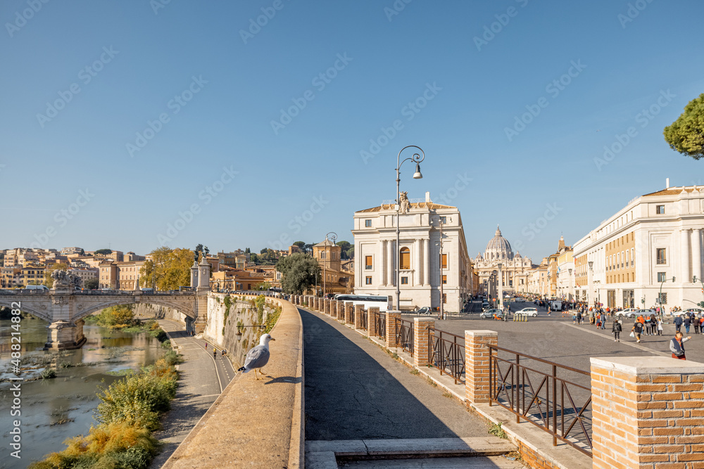 Coast of the Tiber river near castle and Vatican in Rome at sunny day. Seagull walking along the parapet