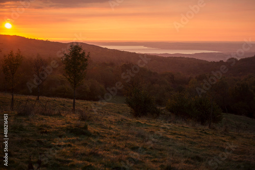 sunrise in the mountains with orange sky with a view on lake garda