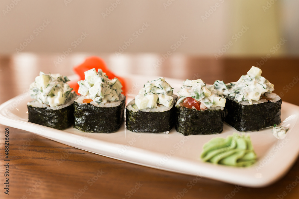 Traditional delicious fresh sushi roll set on a plate in restaurant. Sushi menu. Japanese kitchen, restaurant. Traditional delicious fresh sushi roll set on a plate in restaurant. Sushi menu. Japanese kitchen, restaurant.