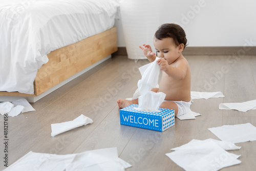 Baby making mess with tissue paper