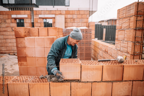 Portrait of professional construction worker, mason, bricklayer building walls