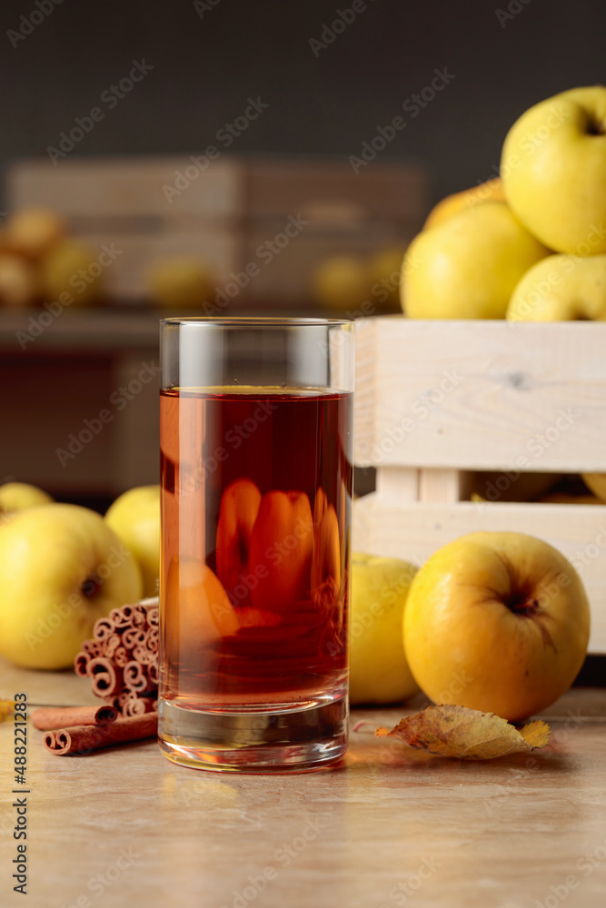 Fresh juicy apples in in wooden box and glass of apple juice.