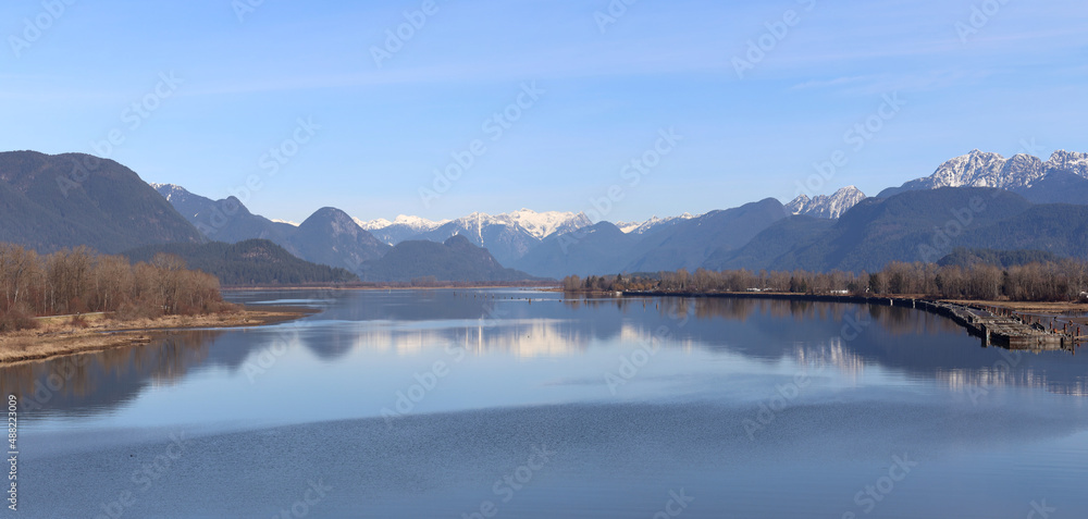 Peaceful river reflecting snow-capped mountains