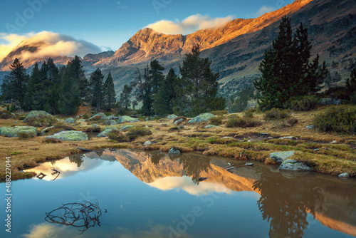 Lake formed by rain in the Benasque valley, with reflections of the mountains at sunset, Pyrenees Huesca, Spain