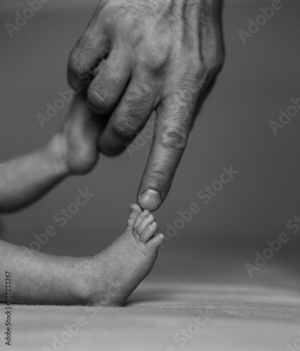 dad touching toes of newborn son