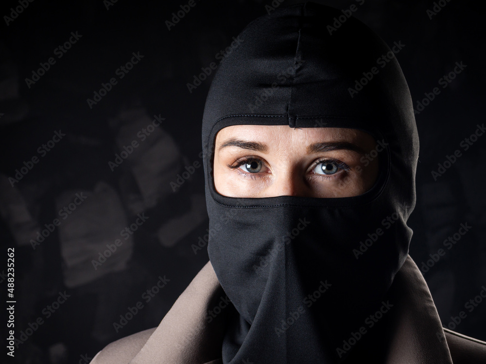 Portrait of a girl in a black balaclava and beige coat. Portrait of a girl in a black balaclava and beige coat.
