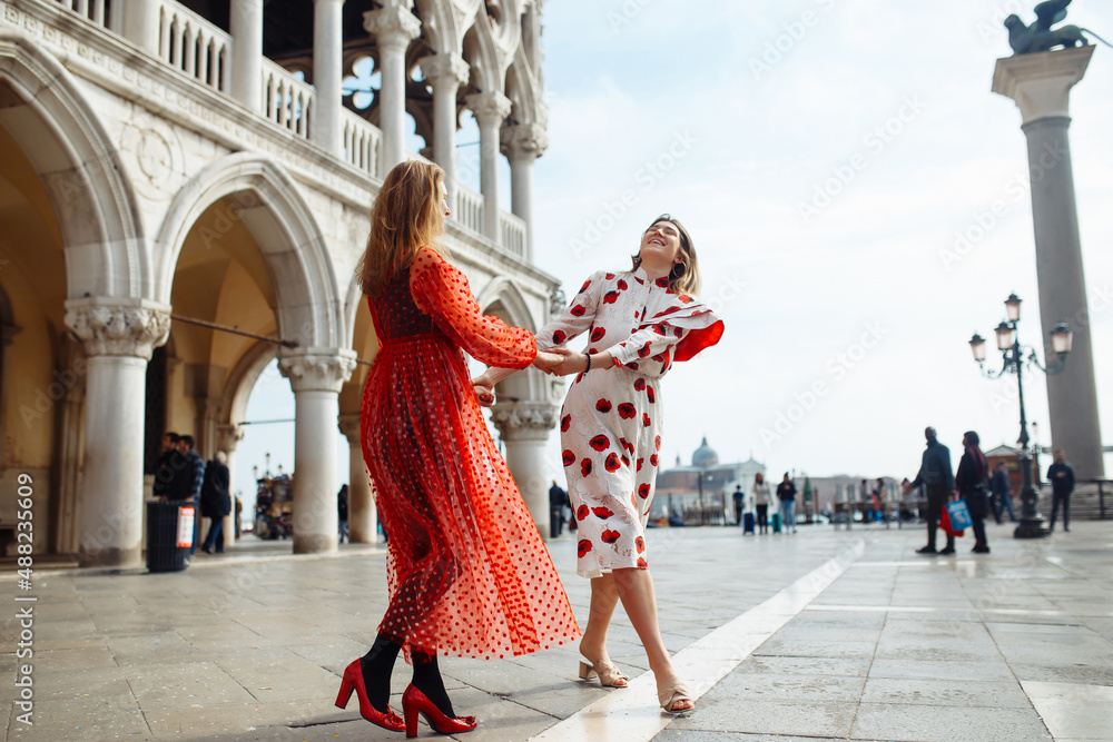 Obraz premium Mom and daughter in fashionable dresses walk around Venice. Lifestyle, travel, tourism.