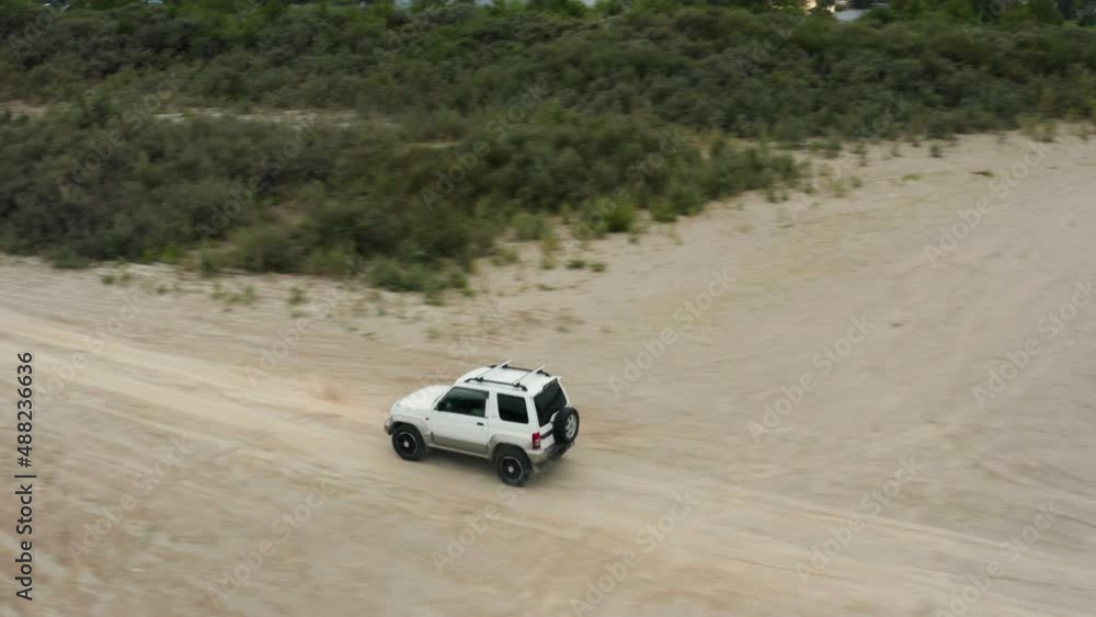 Aerial view of a car driving on sand
