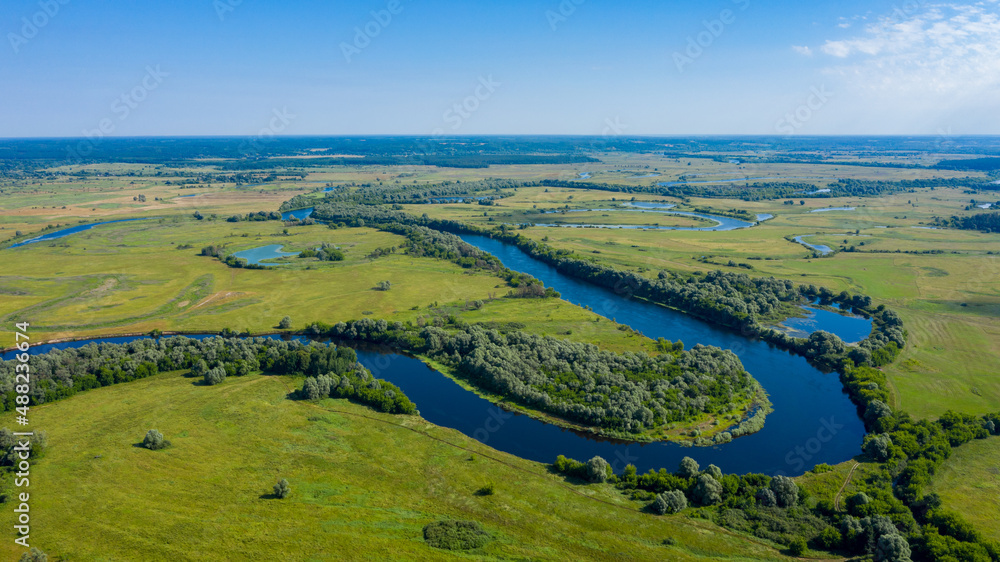 Aerial  view of a beautiful summer  landscape over river. Wide green valley with a river running in the middle. Green meadows. Top view over beauty nature.