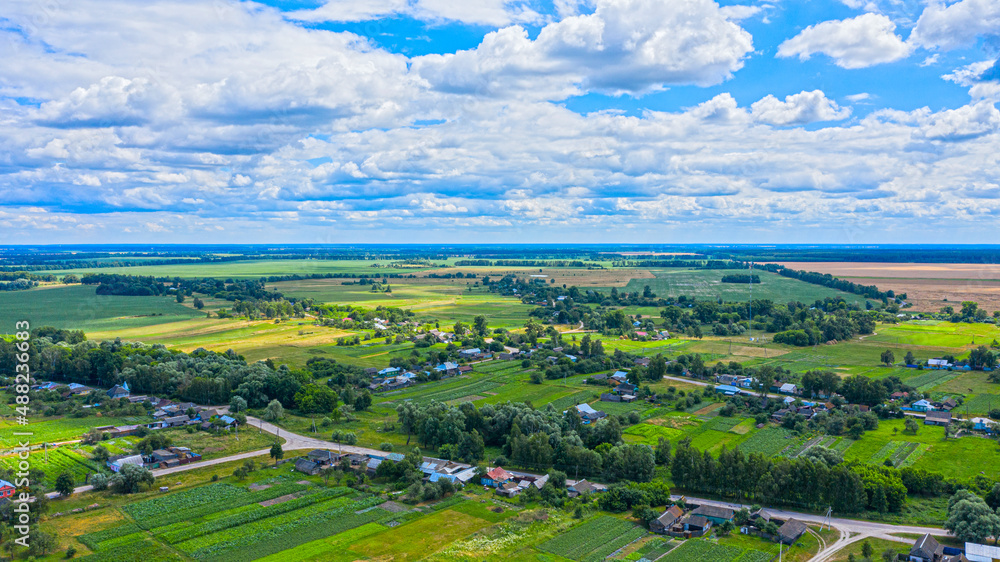 Naklejka premium Aerial view over beautiful suburb in wide valley, in the summer. Top view to the small village with a beautiful green landscape.