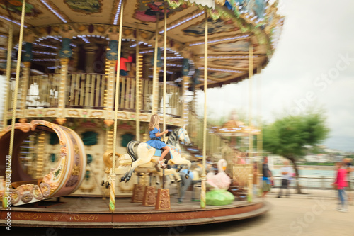 Donostia, Pais Vasco, Spain. 08th may 2017. Little girl riding on the Carousel Palace located in front of the town hall of San Sebastian. Shoot using panning technique to get a sense of movement.