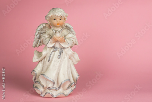 angel figurine on a pink background