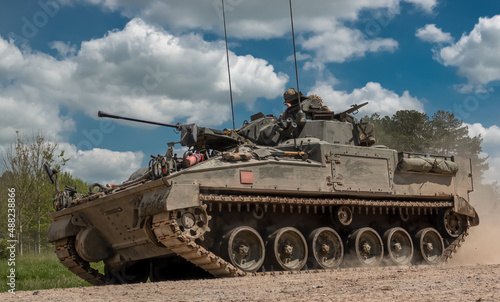 detailed close-up of a British army Warrior FV510 light infantry fighting vehicle tank in action on a military exercise  blue sky with light clouds  Wiltshire UK