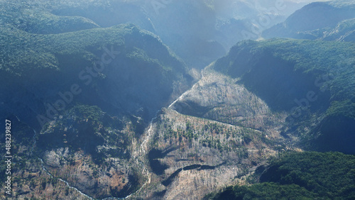 Canyon et montagnes érodées : vue aérienne avec rivières et végétation dans la brume