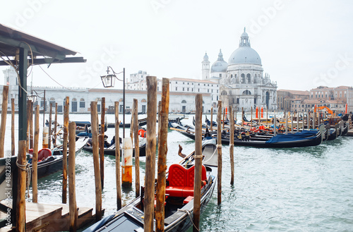 Foto of Gondolas traditional boats moored in wooden pier dock of Grand Canal waterway in Venice historical city centre with row of colorful buildings Venetian architecture, Italy. Travel, tourism  © maxbelchenko