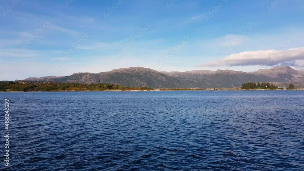 Calm sea with mountains on the background. Norwegian landscape Calm sea with mountains on the background. Norwegian landscape