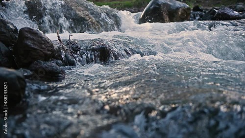 Slow motion of Norwegian mountain river , stream flowing through rocks. Close up of river stones with flowing water, clean water flowing in a mountain river at the Norway