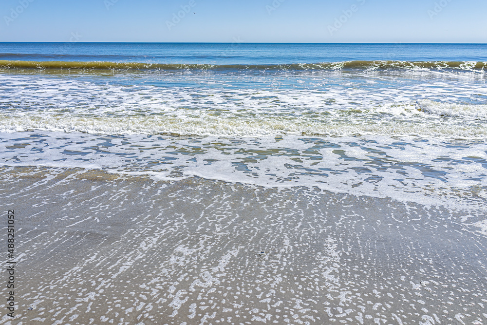 Obraz premium Myrtle Beach, USA shore coast at South Carolina with Atlantic ocean shore sunny day with view of blue sky horizon and sea foam waves