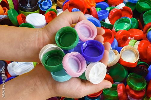 two hands with plastic caps on the background of plastic caps. The concept of secondary raw materials, recycling. Responsible consumption. Separate garbage collection. Ecology.recycling. plastic.