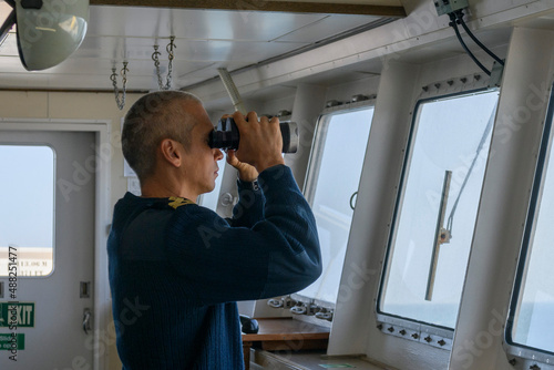 Fotobehang Deck officer with binoculars on navigational bridge