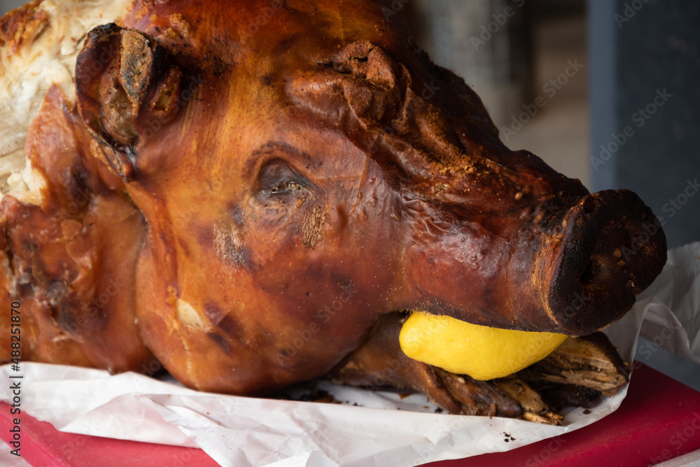 Roasted pig head with lemon. Grilled pork.  Et the entry of butcher delicatessen shop.