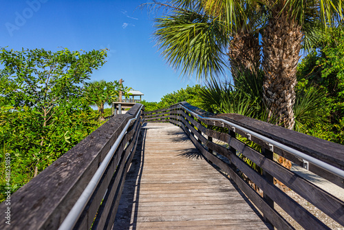 Fototapeta Naklejka Na Ścianę i Meble -  Marco Island near Naples Florida in Coller County with wooden boardwalk path to Tigertail Beach access lagoon on sunny summer day with nobody in tropical landscape