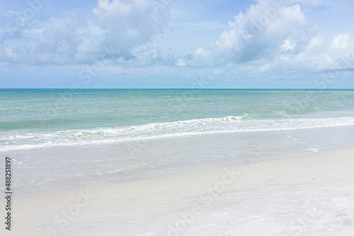 Naples beach in Southwest Florida with blue green idyllic water on summer day gulf of mexico coast horizon in paradise landscape nobody