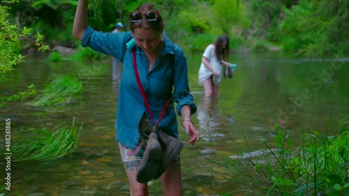 Hikers wade across flooding river