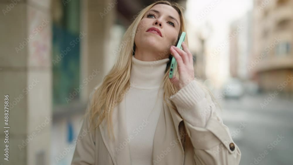 Young blonde woman smiling confident talking on the smartphone at street Young blonde woman smiling confident talking on the smartphone at street