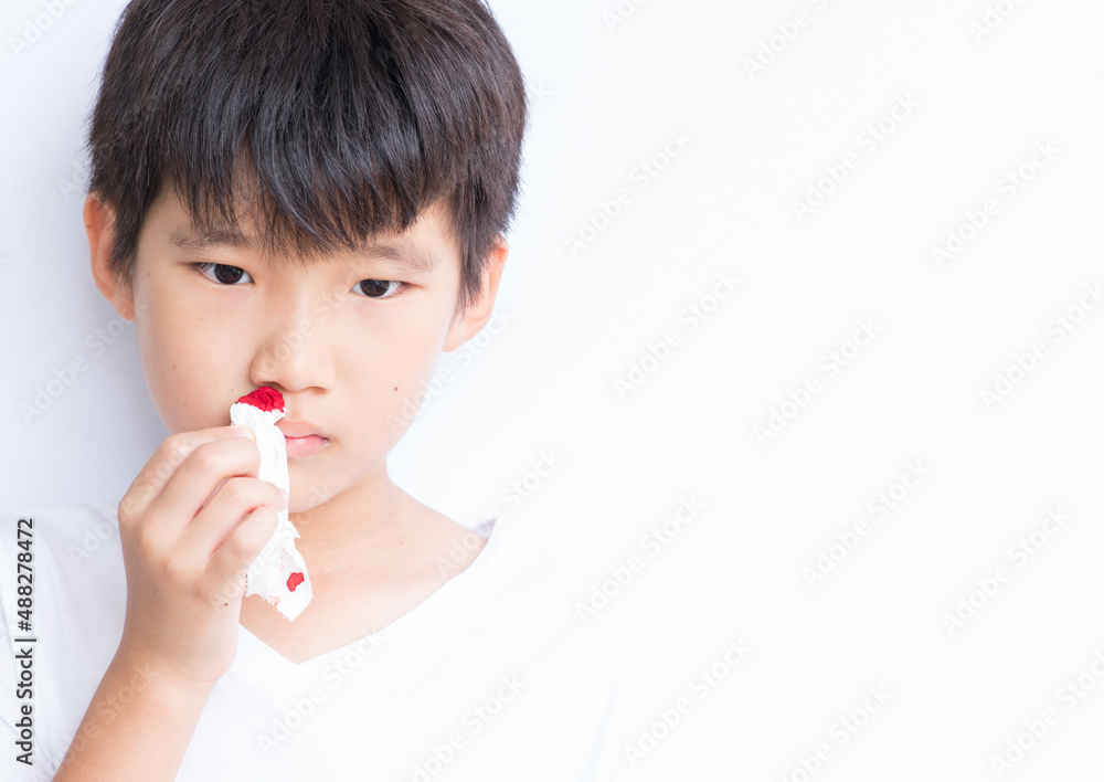 Young boy using tissue to stop nose from bleeding. Isolated in white background. Young boy using tissue to stop nose from bleeding. Isolated in white background.