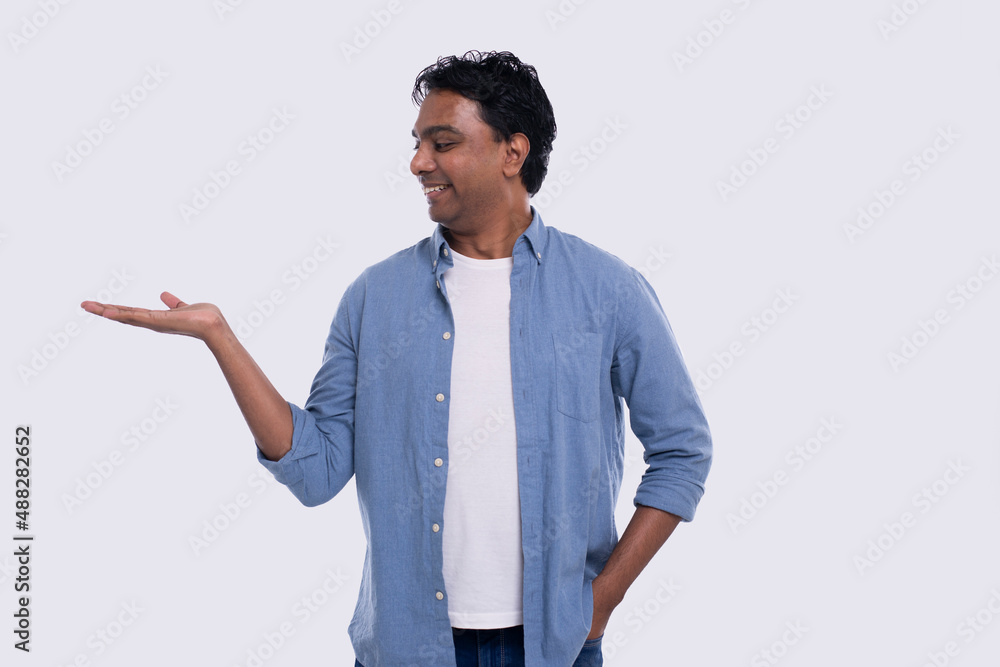 Man Holding Hand to Side Watching to Side Isolated. Indian Man Smilling. Commercial, Advertisment Concept Man Holding Hand to Side Watching to Side Isolated. Indian Man Smilling. Commercial, Advertisment Concept