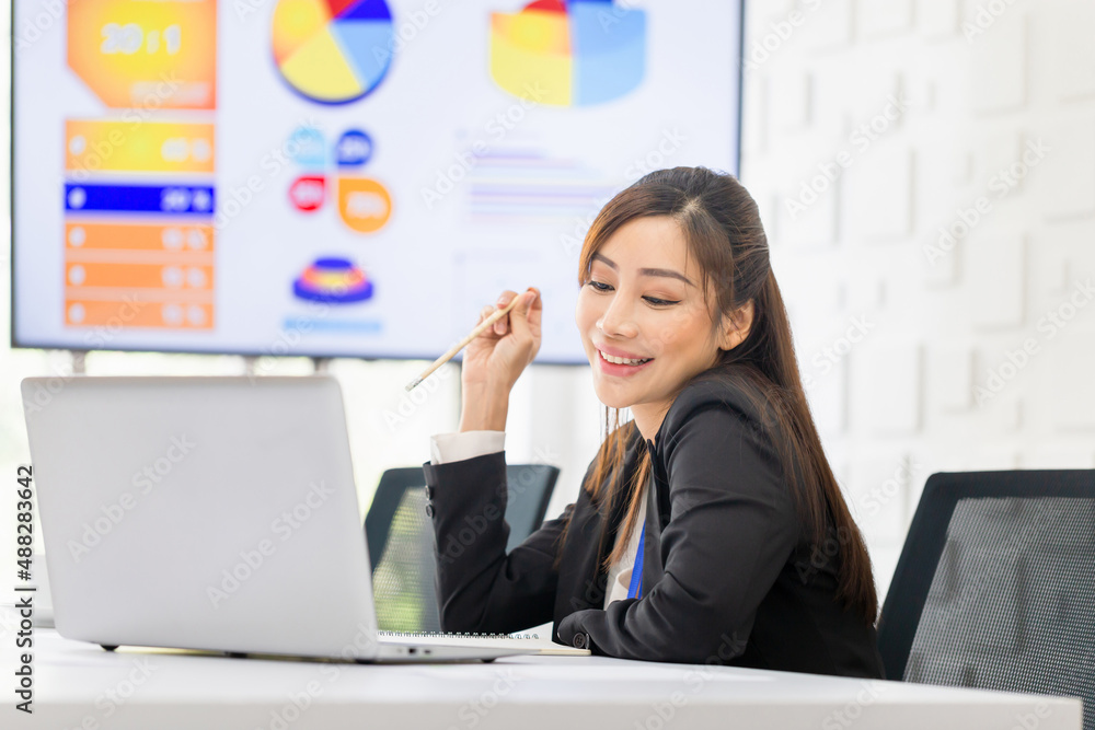 Portrait of young business woman working at laptop, Female doing desk work in modern office workplace, Attractive office worker sitting at desk Portrait of young business woman working at laptop, Female doing desk work in modern office workplace, Attractive office worker sitting at desk