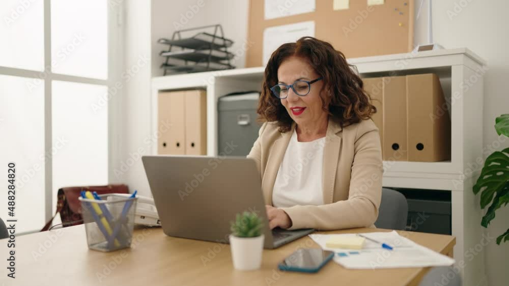 Middle age woman business worker using laptop working at office Middle age woman business worker using laptop working at office