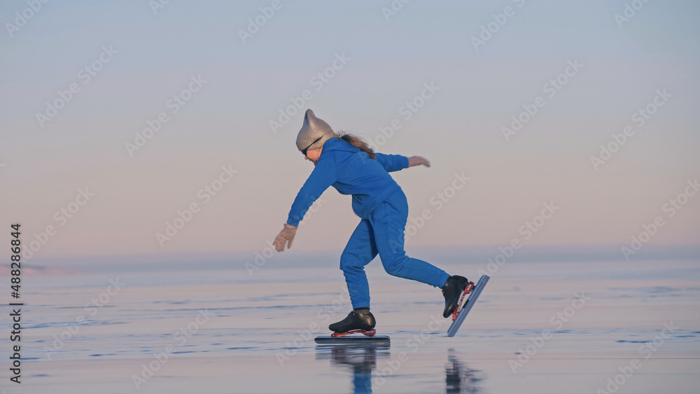The child train on ice professional speed skating. The girl skates in the winter in sportswear, sport glasses, suit. Children speed skating short long track, kid sport. Outdoor slow motion. The child train on ice professional speed skating. The girl skates in the winter in sportswear, sport glasses, suit. Children speed skating short long track, kid sport. Outdoor slow motion.