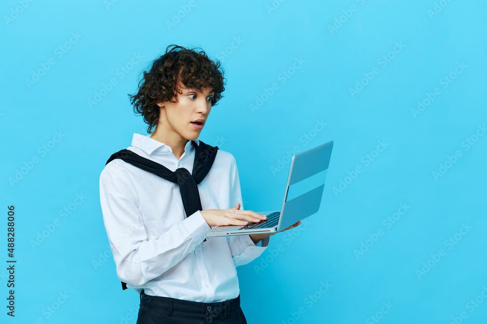 student with laptop internet in a white shirt with a sweater blue background