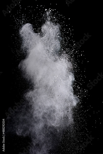Freeze motion of white color powder exploding on dark background.