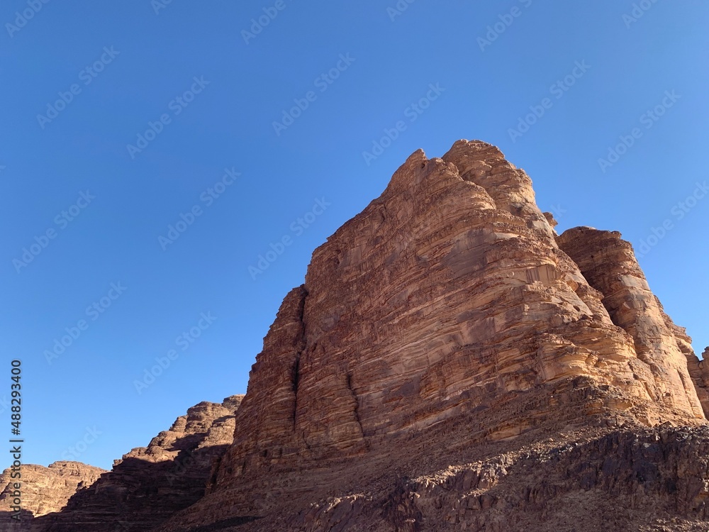 stone rock in the desert against the blue sky and sand
