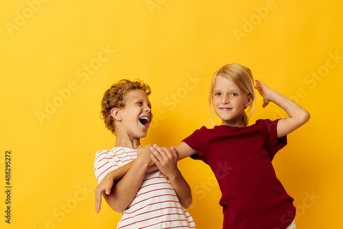 cheerful children cuddling fashion childhood entertainment yellow background