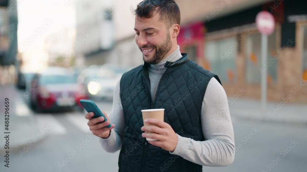 Young hispanic man using smartphone and drinking coffee at street Young hispanic man using smartphone and drinking coffee at street