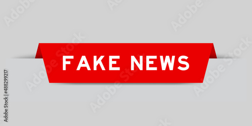 Red color inserted label with word fake news on gray background
